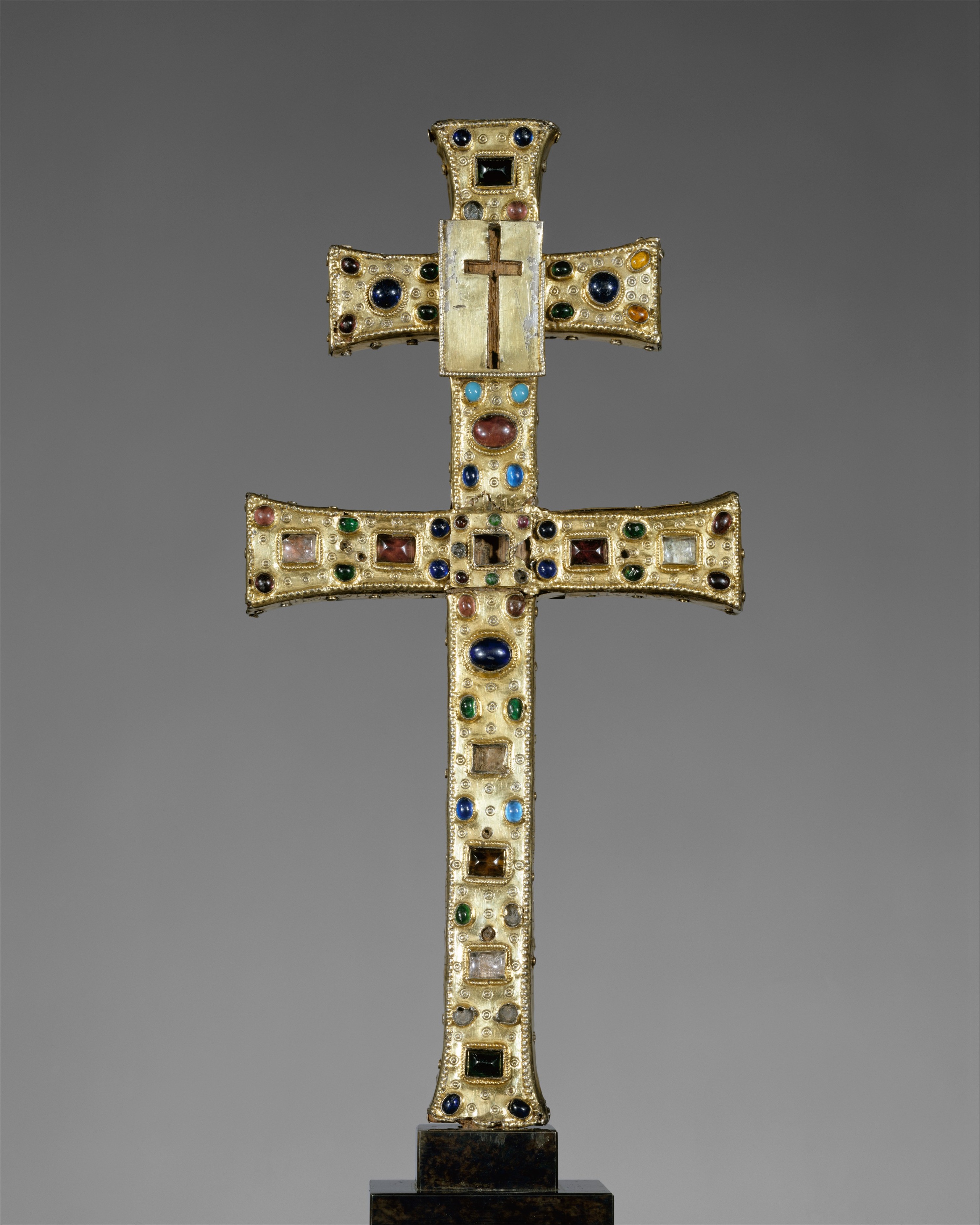 French gilded-silver reliquary cross made around 1180 with colored glass and labeled relic compartments