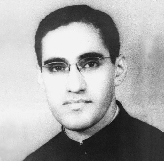 Óscar Romero as a young man wearing glasses and a clerical collar.
